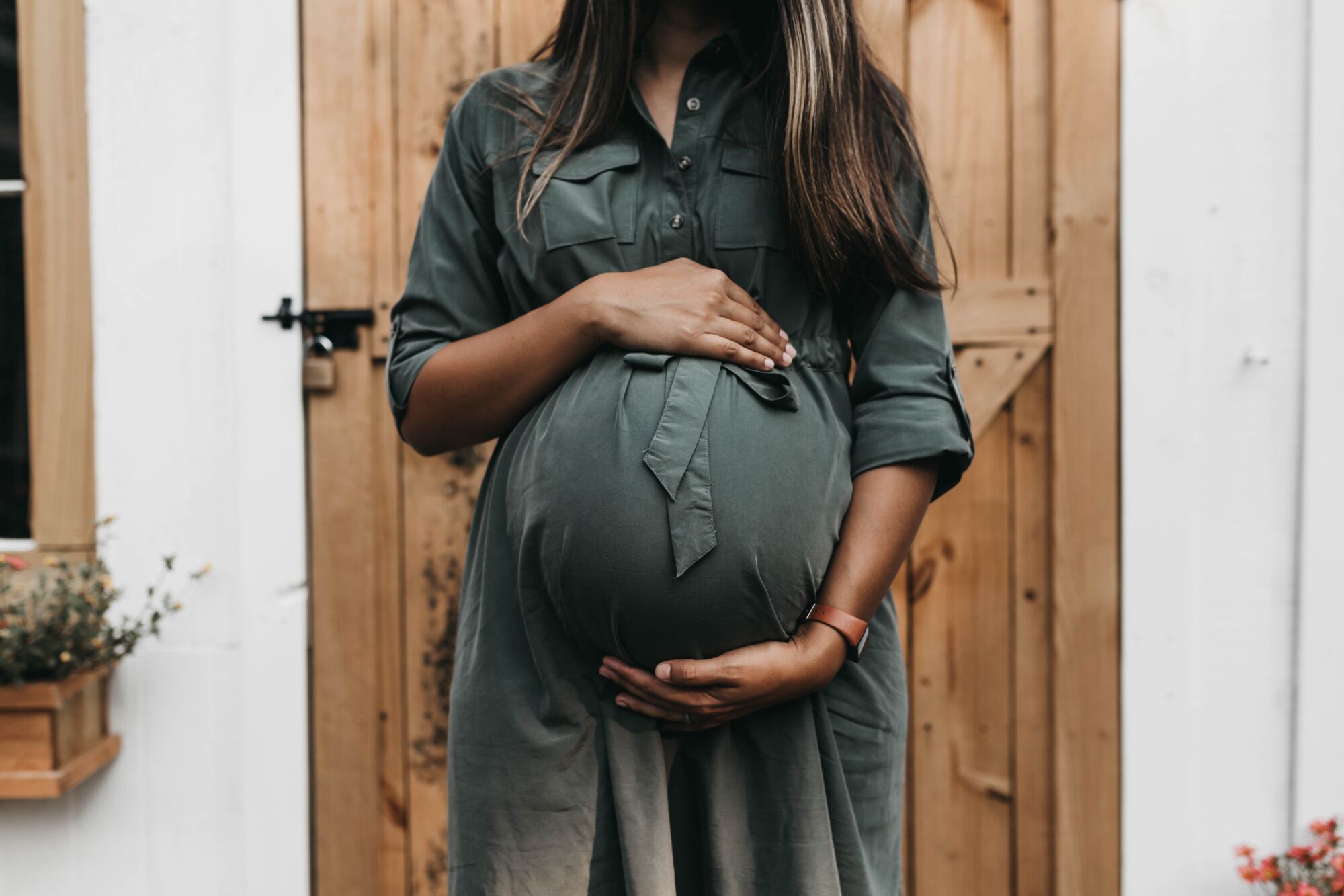 black pregnant woman standing wondering if osteopathy is safe during pregnancy