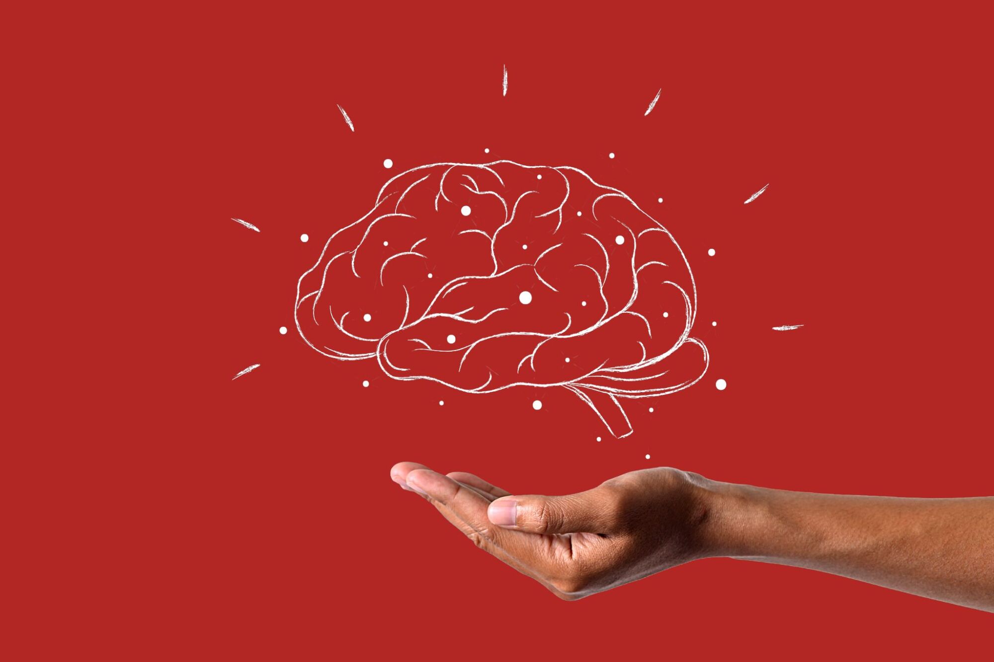 Red background with female hand holding a white sketch of a brain
